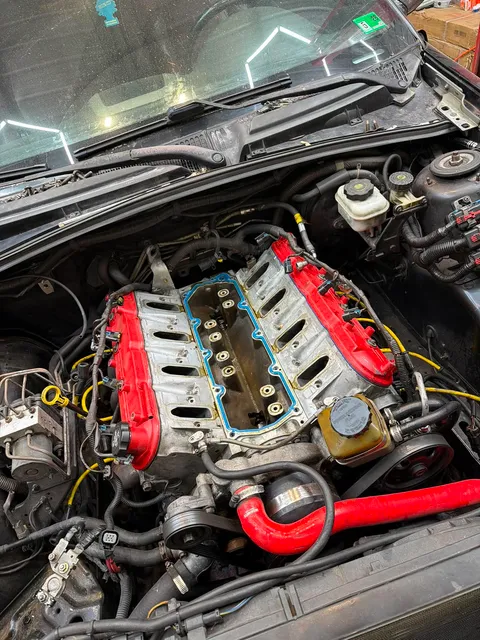 LS Engine Build — Close-up of an LS V8 engine undergoing assembly or maintenance, highlighting bright red valve covers and intake valley.