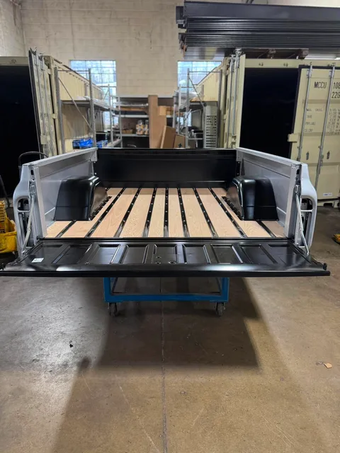 Restored Truck Bed — Rear view of a restored classic pickup truck bed featuring beautifully finished wood planks and metal strips.